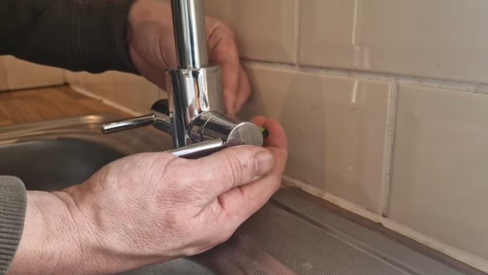 Plumber repairing a kitchen faucet