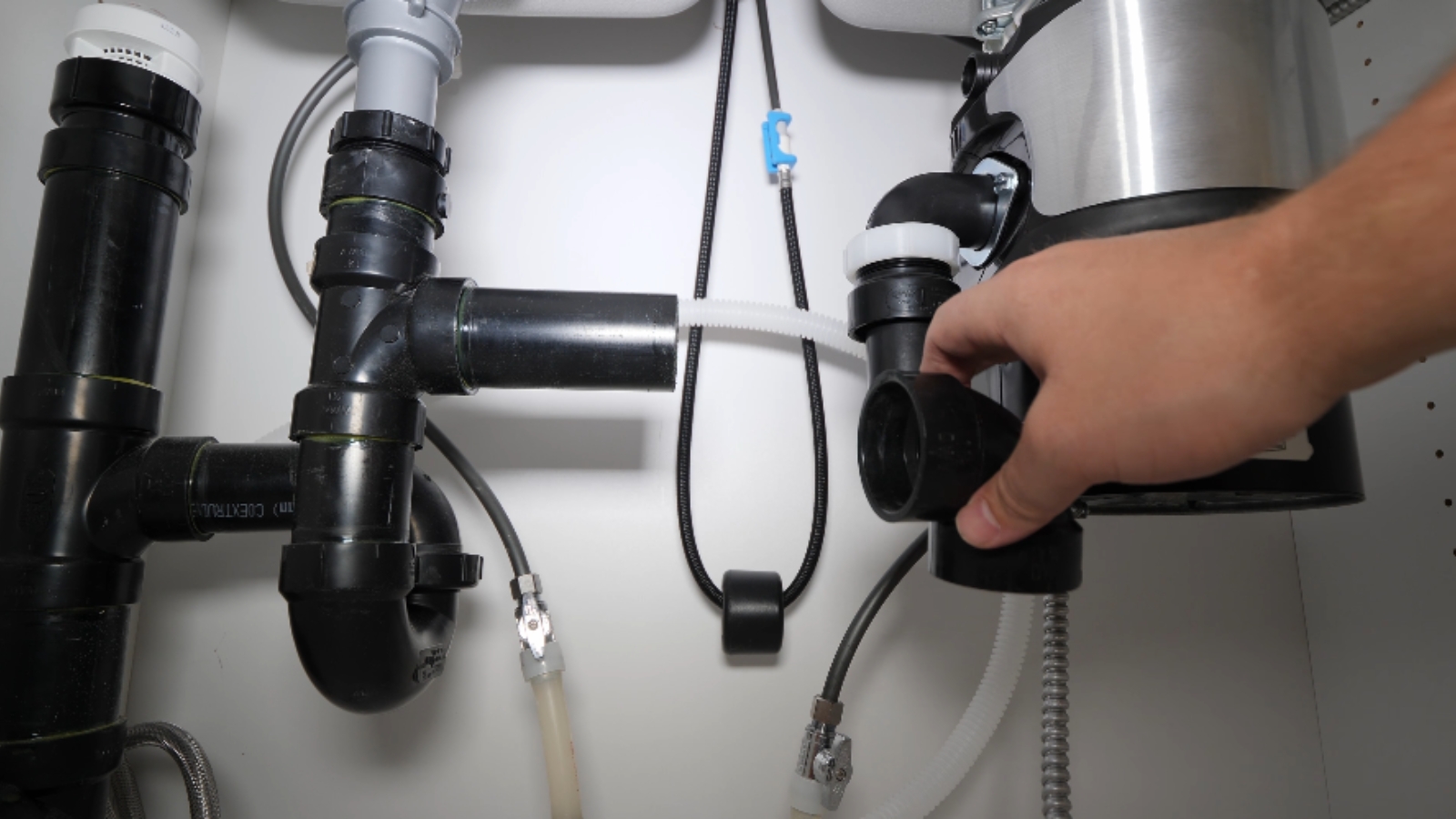 Garbage disposal being installed under a kitchen sink