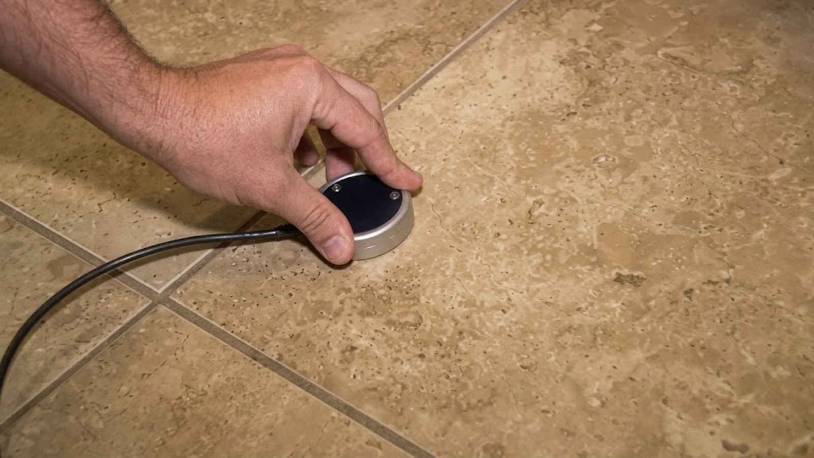 Technician using leak-detection equipment on a concrete slab floor