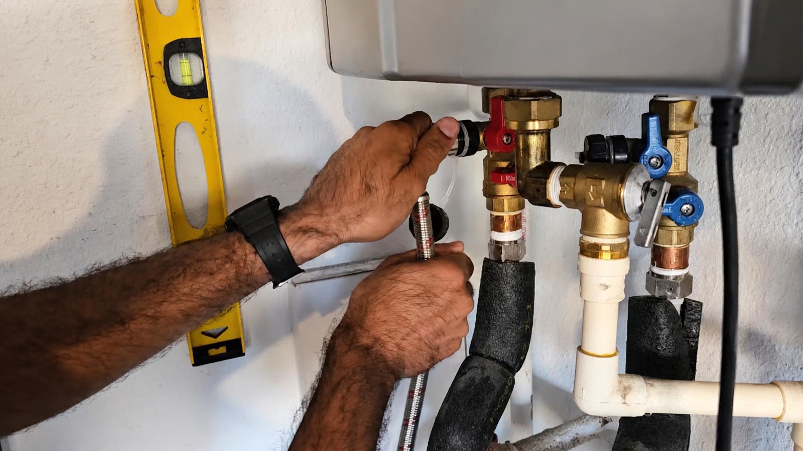 Technician servicing a wall-mounted tankless water heater